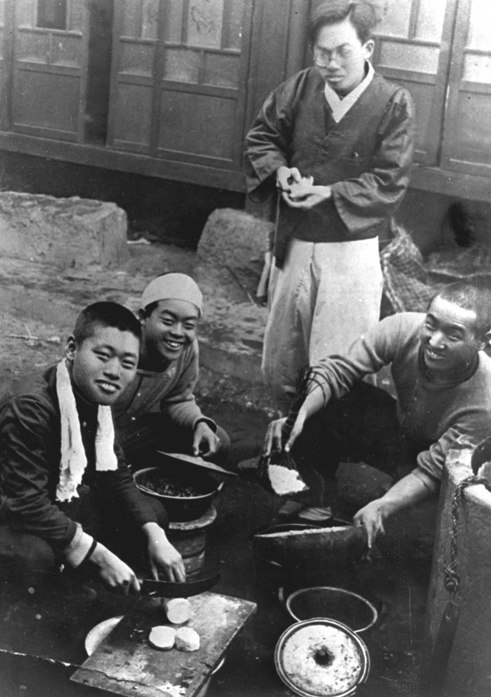 Доктор Мун (праворуч) готує рис зі своїм двоюрідним братом Мун Син Рьоном (другий ліворуч) і друзями.